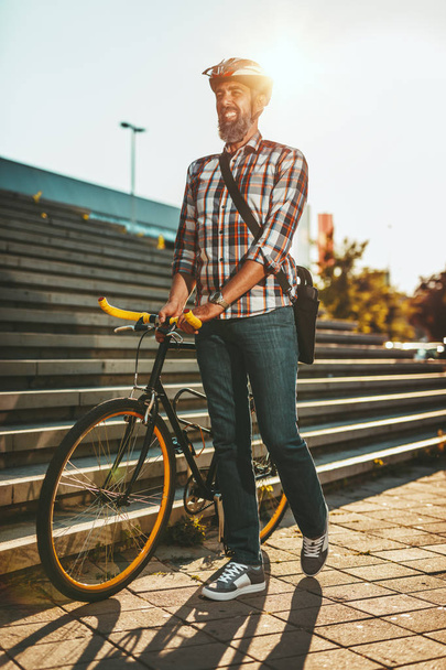 Kypsä rento liikemies menossa töihin polkupyörällä
 - Valokuva, kuva
