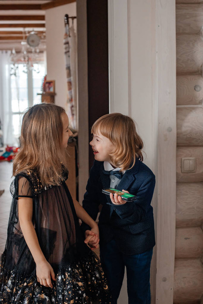 hermano y hermana en ropa festiva jugando en casa
 - Foto, imagen