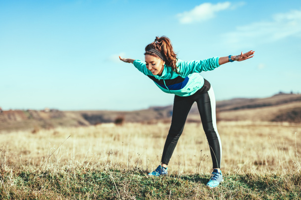 Giovane donna fitness che fa esercizio di stretching dopo aver fatto jogging all'aperto
 - Foto, immagini