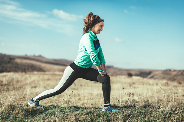Genç fitness kadının açık koşu sonra germe egzersiz yapması - Fotoğraf, Görsel