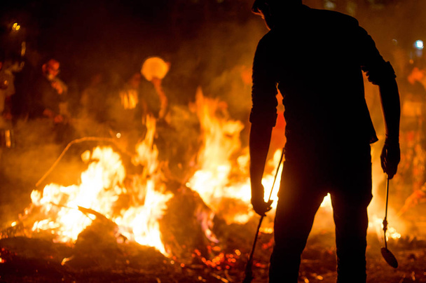 Silueta de personas frente al fuego tostando grano para el festival Holi Lohri
  - Foto, imagen
