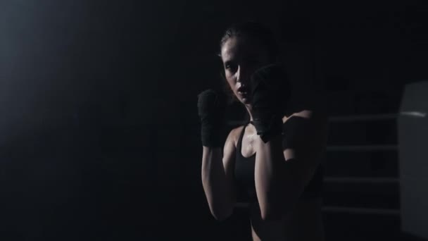 Female boxer fist close up - boxer strikes into the side of the camcorder. Spectator video boxing. The woman is striking the opponent. Slow motion - Video, Çekim