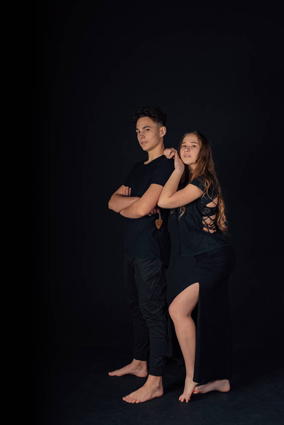 young lovely couple posing in studio on black background  - Foto, Imagen