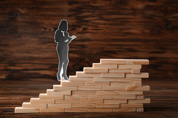 Stacked blocks with human figure on wooden background. Concept of career - Photo, Image