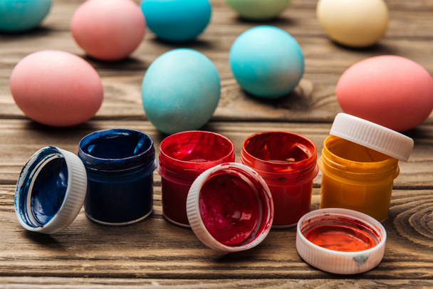 mise au point sélective de peintures acryliques et d'œufs de Pâques pastel sur une table en bois
 - Photo, image