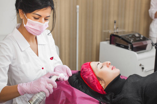 美容師は、顔の持ち上げ手順を作ります。皮膚科医はフェイスマスクを適用する。クリニックでの美容トリートメント. - 写真・画像