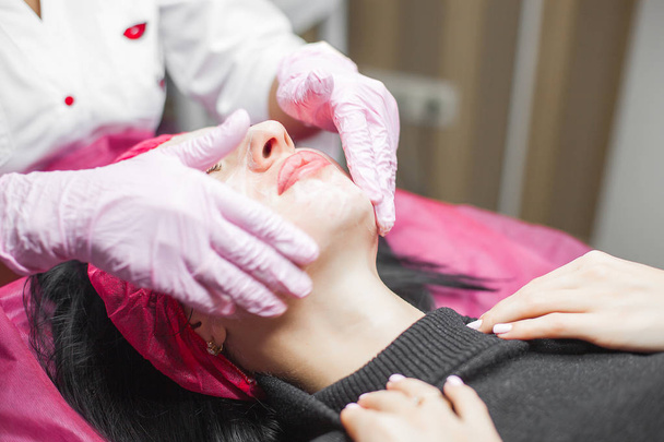 Cosmetologue faisant une procédure de lifting du visage. Dermatologue appliquant un masque facial. Soins de beauté à la clinique
. - Photo, image