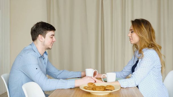 couple sits at table join hands and pray before breakfast - Photo, Image