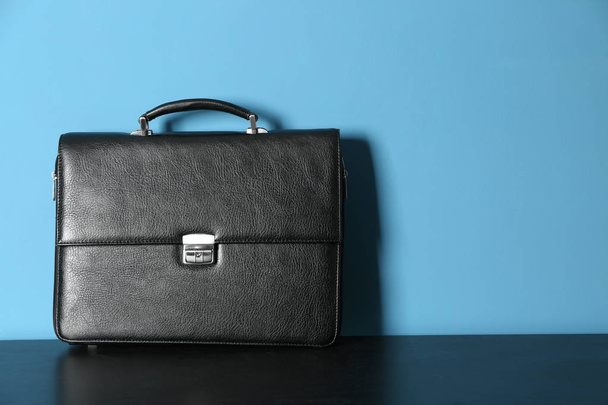 Male briefcase on table against color background - Valokuva, kuva