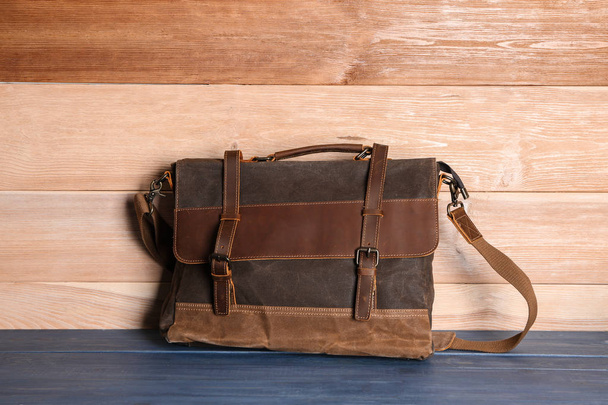 Male briefcase on table against wooden background - Photo, Image