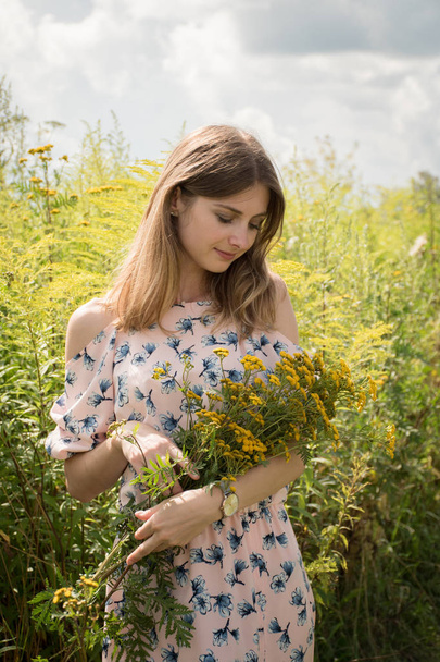 beautiful young girl in a meadow among herbs and flowers - Фото, зображення