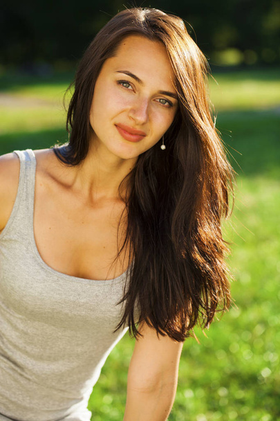 Young brunette woman in summer park - Fotó, kép