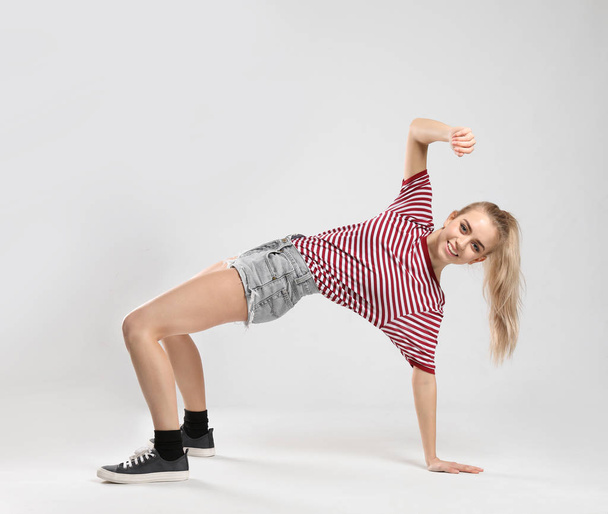 Young female dancer on light background - Foto, afbeelding