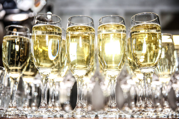 verres de vin mousseux blanc pétillent dans la lumière. fond de verres avec vin mousseux
  - Photo, image