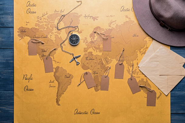 Kaart met kompas en tags op houten tafel - Foto, afbeelding