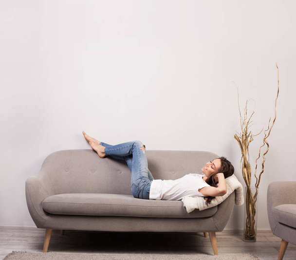 beautiful happy young woman lying on a sofa - Zdjęcie, obraz