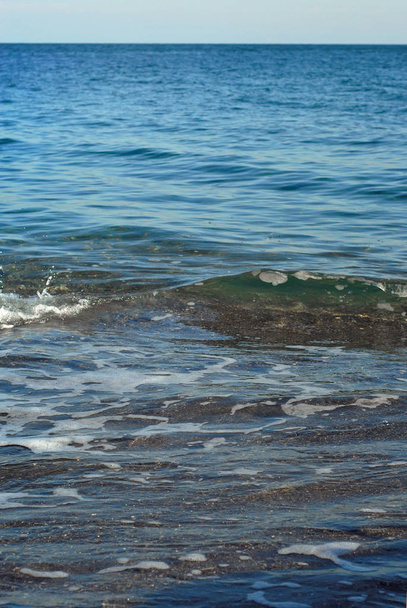 Rocky coast of the sea. Waves on the beach. Blue sea water. - Zdjęcie, obraz