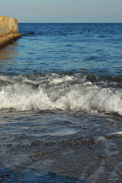 Rocky coast of the sea. Waves on the beach. Blue sea water. - Foto, afbeelding