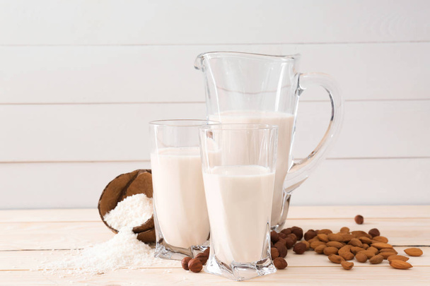 Assortiment van smakelijke veganistische melk op houten tafel - Foto, afbeelding