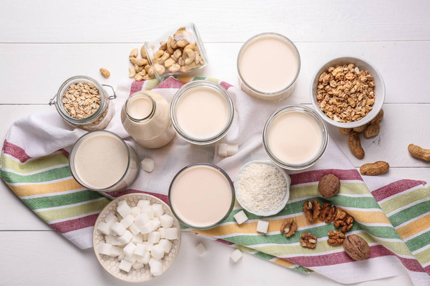 Beyaz ahşap masada lezzetli vegan süt çeşitleri - Fotoğraf, Görsel