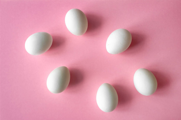 six white chicken eggs on pink background side with place for inscription - Foto, Imagem