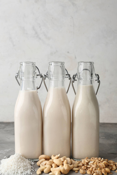 Az ízletes vegán tej választéka szürke asztalon - Fotó, kép