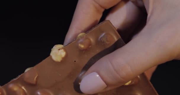 Barra de bloque de chocolate negro en primer plano de la mano de la mujer
 - Metraje, vídeo