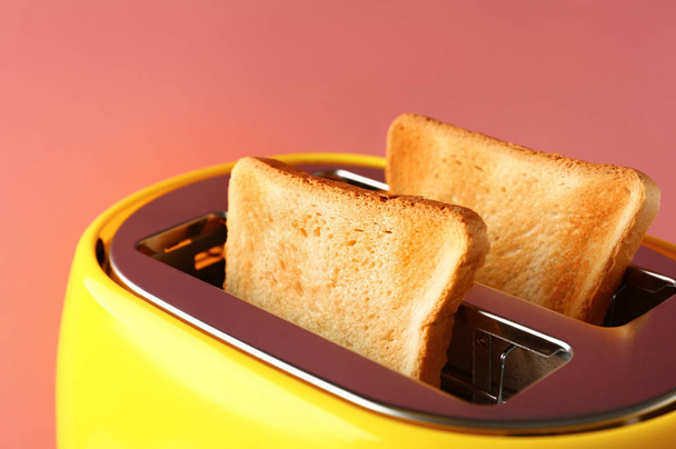 Τοστιέρα με φέτες ψωμιού σε χρώμα φόντο, κοντινό πλάνο - Φωτογραφία, εικόνα