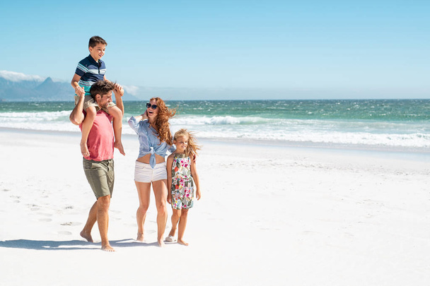 Family walking at beach - Foto, afbeelding