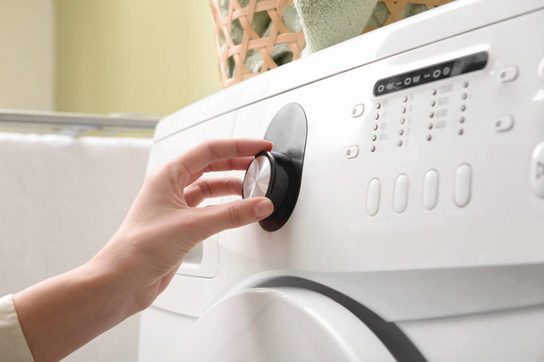 Frau schaltet Waschmaschine ein, Nahaufnahme - Foto, Bild