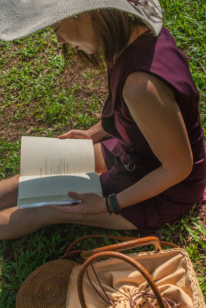 Dziewczyna czytająca książkę w parku - Zdjęcie, obraz