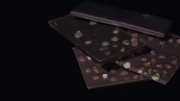 Темні шоколадні блоки з горіхами деталі сповільнюють макрос крупним планом. Перспектива з шоколадних батончиків
 - Кадри, відео