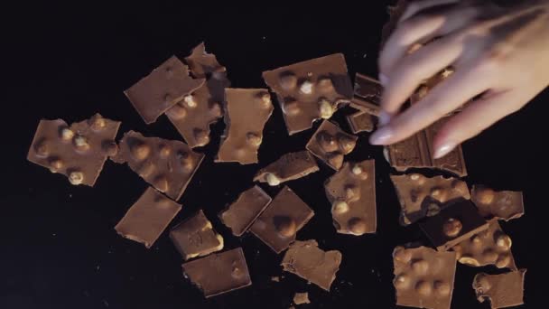 Nő kéz viszi egy darab csokoládé darab egy csomó csokit. Lassú mozgás - Felvétel, videó