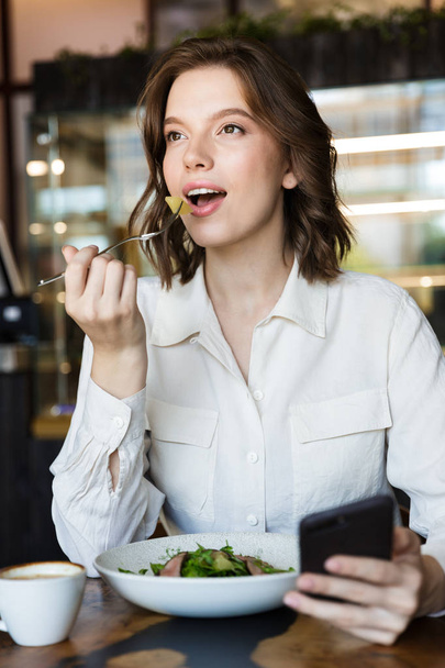 Smiling businesswoman having lucnch at the cafe indoors - Φωτογραφία, εικόνα