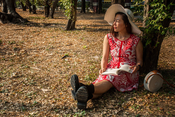 Tyttö lukee kirjaa puistossa
 - Valokuva, kuva