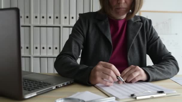 Businesswoman analyzing business data spreadsheet in office, dolly slider shot - Кадры, видео