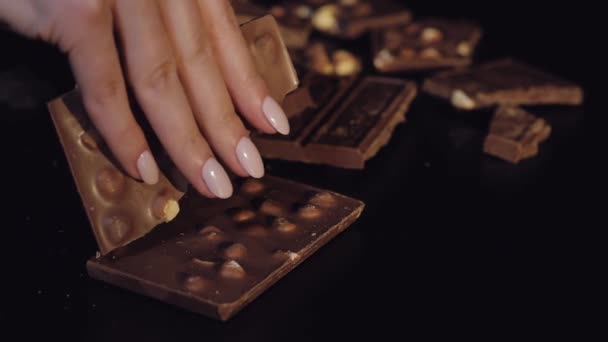 Mujer rompe la barra de chocolate negro con nueces. Primer plano. Movimiento lento
 - Imágenes, Vídeo