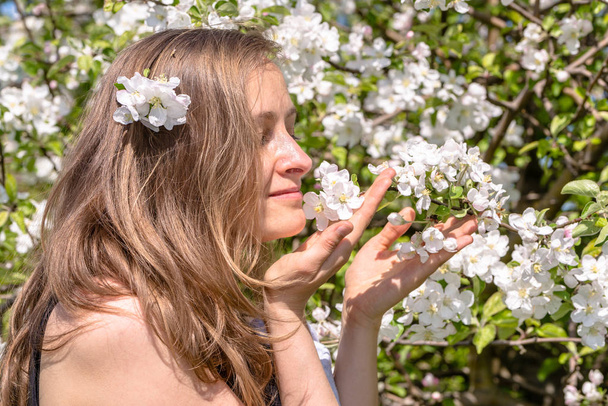 Hermosa mujer entre flores de primavera en el jardín
 - Foto, imagen