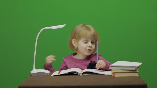 Dziewczyna Rysowanie przy stole. Proces edukacji w klasie. Szczęśliwy trzy lat dziewczyna. Ładna dziewczyna uśmiechając się. Dość małe dziecko, 3-4-letniego Blondynka. Zrobić twarze. Zielony ekran wideo. Kluczowanie kolorem - Materiał filmowy, wideo
