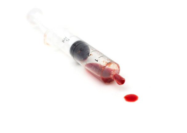 syringe and red blood on white background - Foto, Imagen