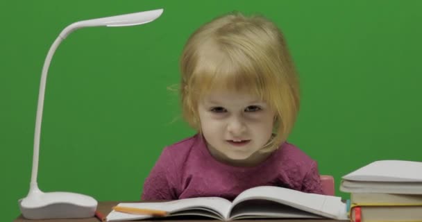 Kız masada çizim. Eğitim sürecinde sınıf. Mutlu üç yaşında bir kız. Sevimli kız gülümsüyor. Küçük çocuk, 3-4 yaşında sarışın kız. Yüzleri olun. Yeşil ekran video. Chroma Key - Video, Çekim