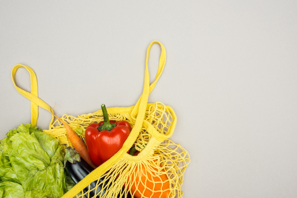 yellow string bag with fresh ripe vegetables on grey background - Fotoğraf, Görsel
