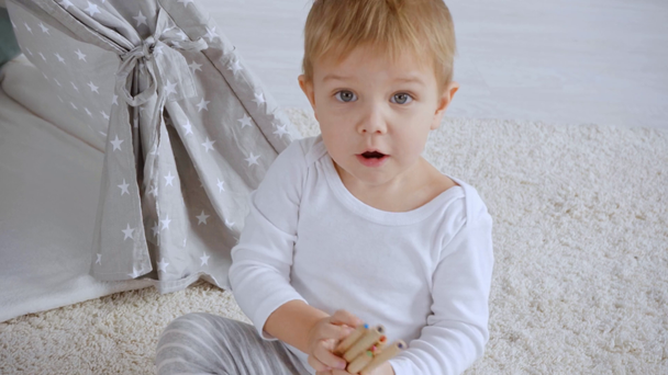 aranyos kisgyermek fiú ülés OB szőnyeg, beszélgetés és tárolás színes ceruzák - Felvétel, videó