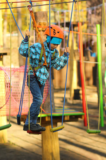 Six year old boy surmounting obstacle course in the outdoor rope park - Photo, Image