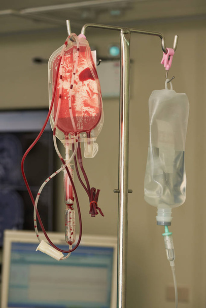 A bag of saline fluid and blood hanging on the pole - Photo, Image