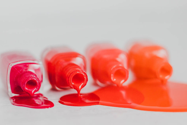 Nagellackflaschen in verschiedenen Rot- bis Orangetönen und pur - Foto, Bild