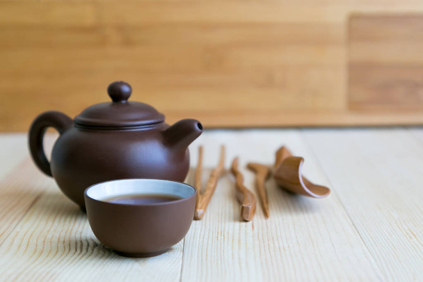 A set accessories for the tea ceremony. Dishes for tea and wooden sticks on a light background. - 写真・画像