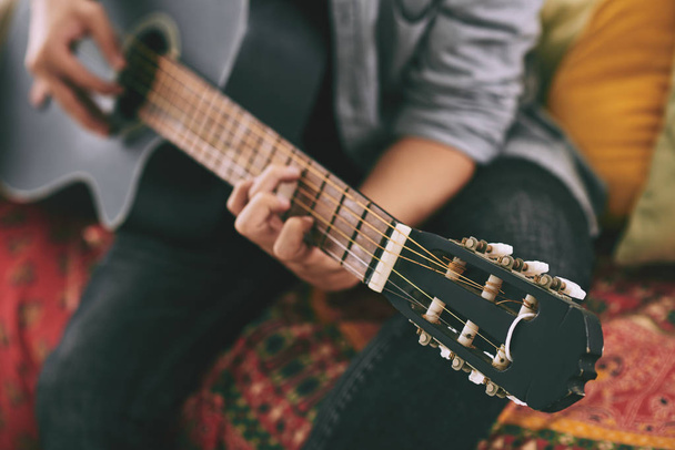 Ο άνθρωπος παίζει ακουστική κιθάρα στο σπίτι, επιλεκτική εστίαση  - Φωτογραφία, εικόνα