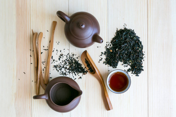 Tea ceremony set and black flavored tea on wooden background . - Valokuva, kuva
