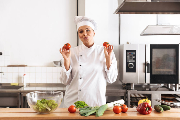 Foto de la divertida mujer chef con uniforme blanco comida de cocina w
 - Foto, imagen